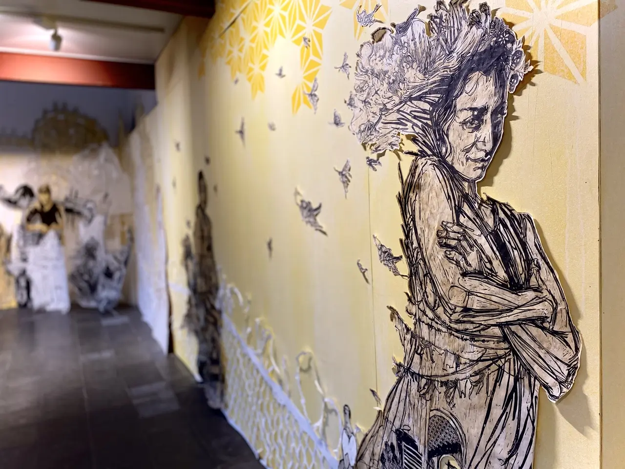 Symbolbild fürs Swoon Urban Art: Porträt einer Frau aus Papier vor gelbem Hintergrund