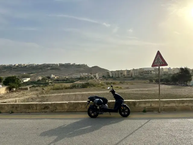 Bild von einem Roller vor einem Dorf auf der Malta-Insel Gozo steht für Reisetipps